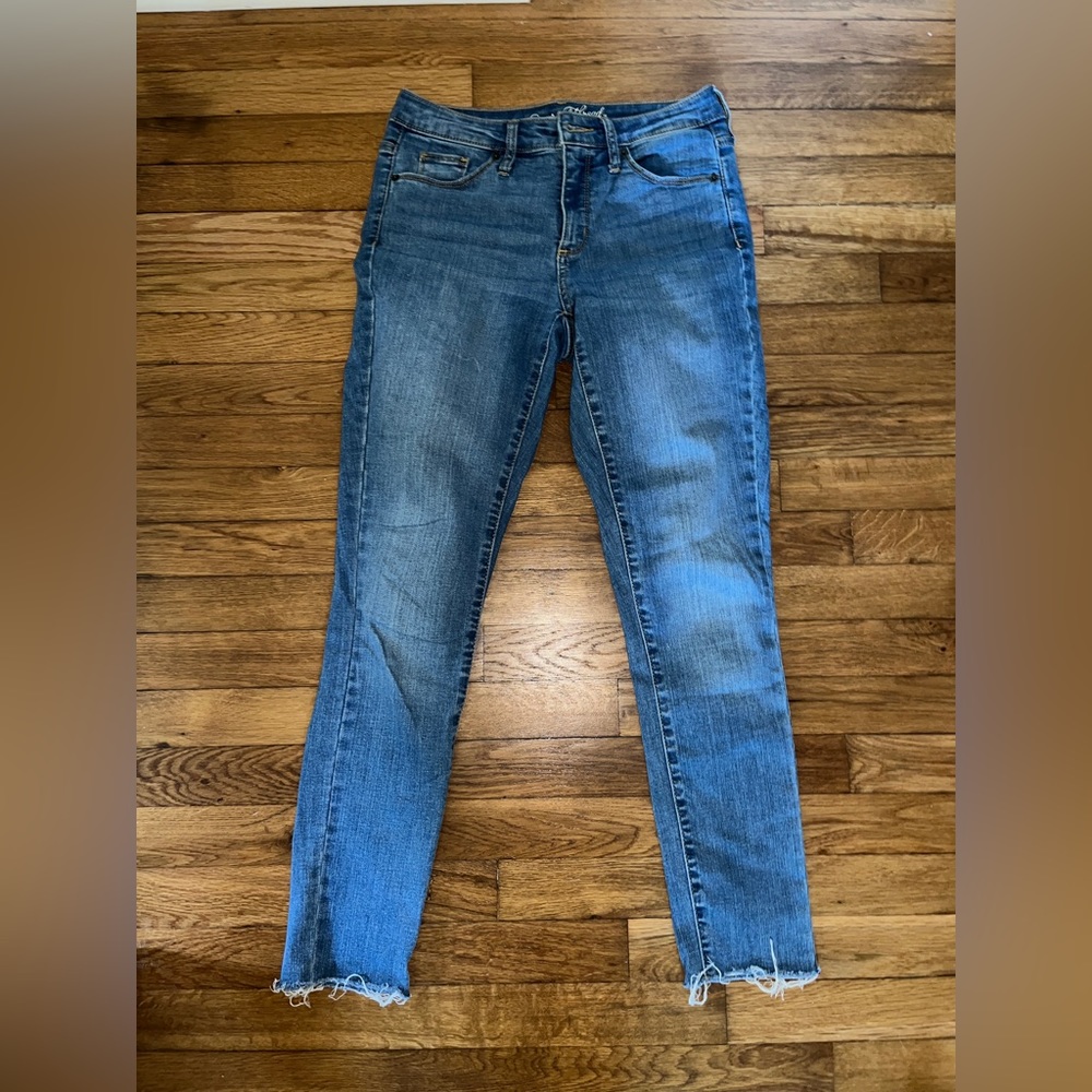 Skinny jeans with rips at the bottom by the ankles.